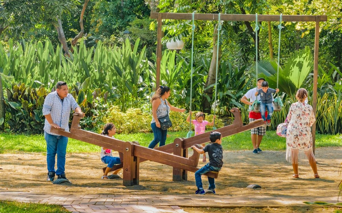 pais e crianças em um parque brincando em gangorra e balanço